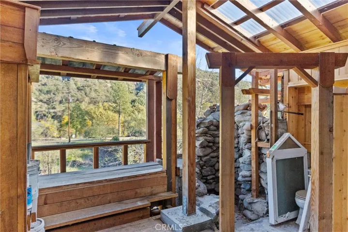 Cabin Interior has Picture Window of Bluff and Creek Area. Note Rock Shower and Conventional Toilet at Right 
l