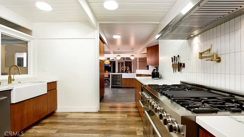 View of back Kitchen looking out to the Backyard. There is a Farmers sink in this area and in the front Kitchen area. Ton's of cabinet space throughout the Kitchen. Notice the beautiful Appliances.