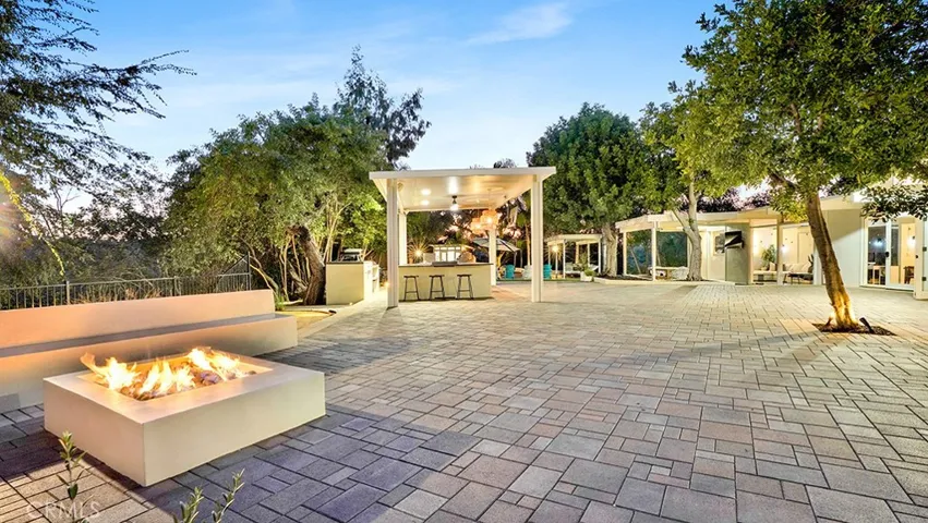 Standing by Fire Pit looking towards Outdoor Kitchen, House and Pool.