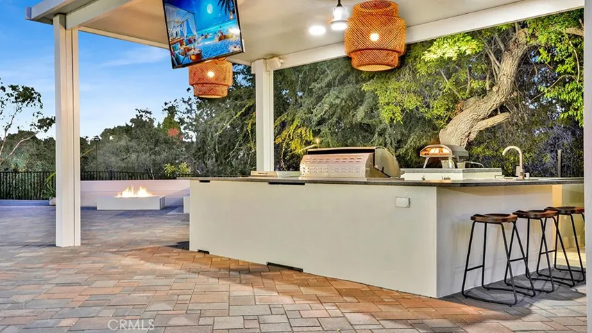 Covered Kitchen / BBQ / Pizza Oven / TV in backyard. Fire Pit w/Seating and Views in background.