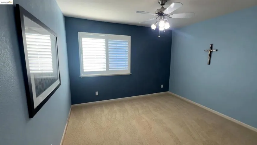 Spare room featuring light carpet and a ceiling fan
