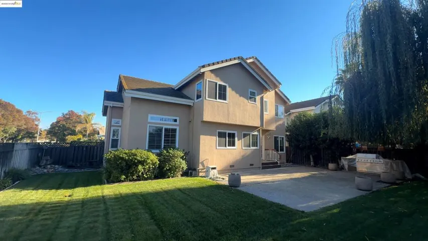 Back of property with a patio area, stucco siding, and a tiled roof