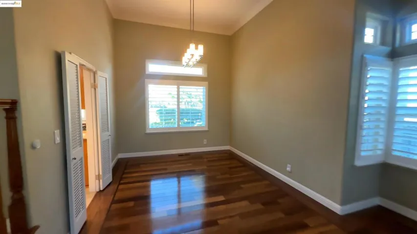 Unfurnished dining area featuring a chandelier and dark wood-style floors