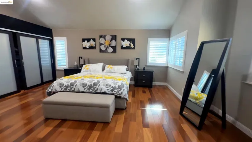 Bedroom with lofted ceiling and wood finished floors