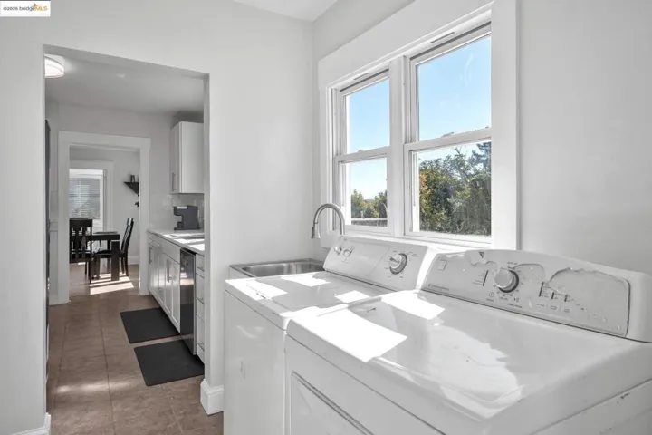 Laundry area with separate washer and dryer and light tile patterned flooring