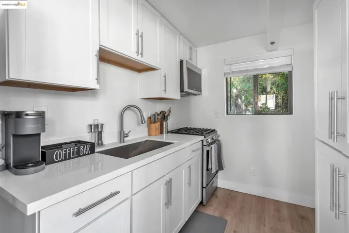 Kitchen featuring white cabinetry, stainless steel appliances, and light wood-type flooring