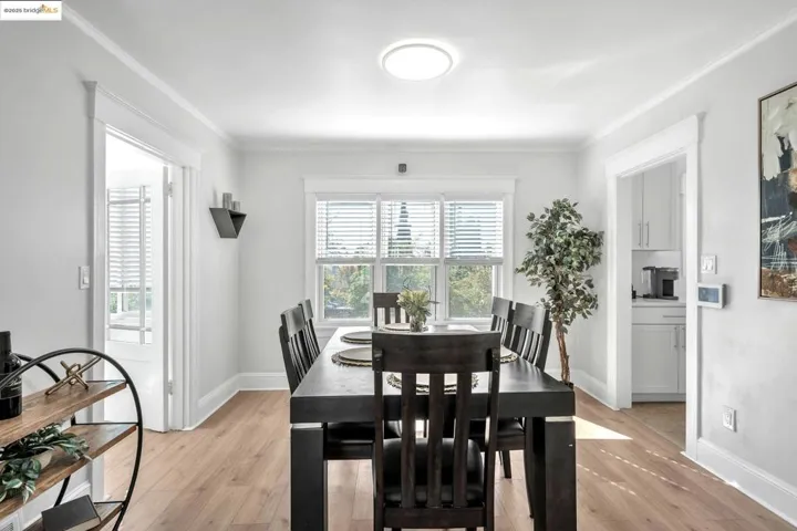 Dining area with light wood-style floors and crown molding
