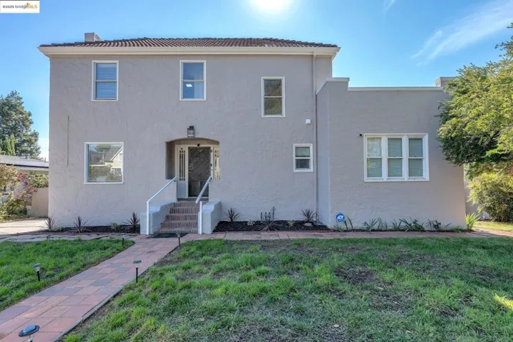 View of front of home with a front yard and stucco siding
