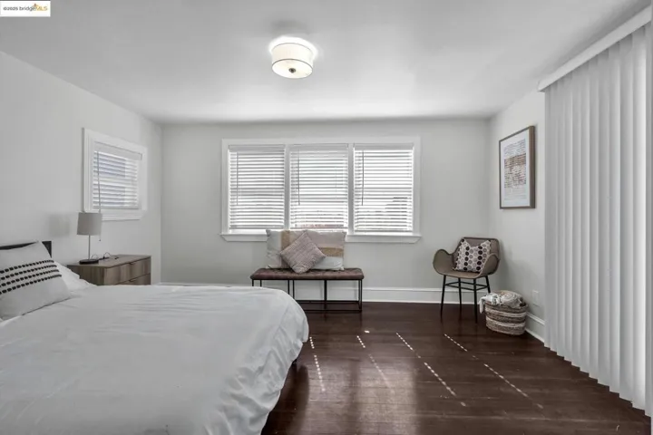 Bedroom with multiple windows and dark wood-style flooring