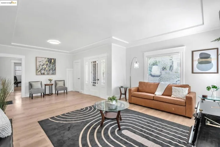 Living room featuring french doors, light wood finished floors, and a tray ceiling