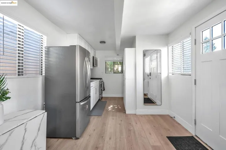 Kitchen featuring white cabinetry, stainless steel appliances, and light wood-type flooring