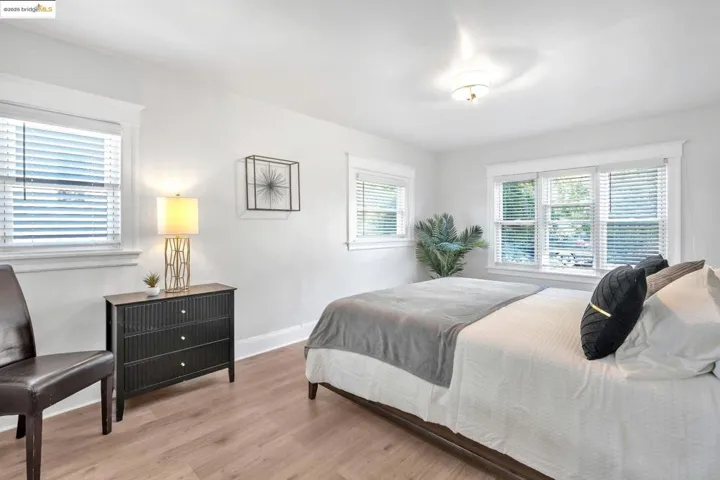 Bedroom with wood finished floors and multiple windows
