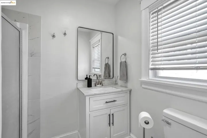 Bathroom with vanity, a stall shower, and plenty of natural light