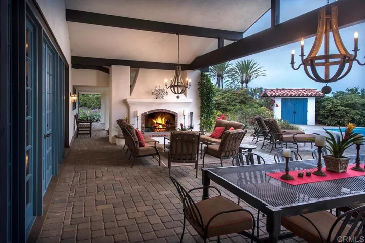 Beautiful outdoor room with dining area and woodburning fireplace