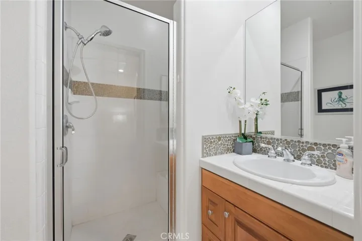 A shower stall is located in the bathroom off the 2nd bedroom, nice white tile and a stone back splash accents the sink area.