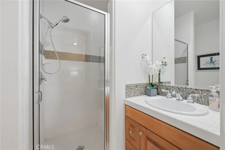 A shower stall is located in the bathroom off the 2nd bedroom, nice white tile and a stone back splash accents the sink area.