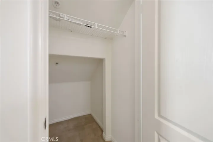A very spacious hall closet with room for storage under the staircase, as well as a coat hanging bar.