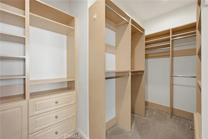 This is the huge walk-in closet in the primary suite, with multiple drawers, a laundry hamper and more storage space on the opposite side of this photo.