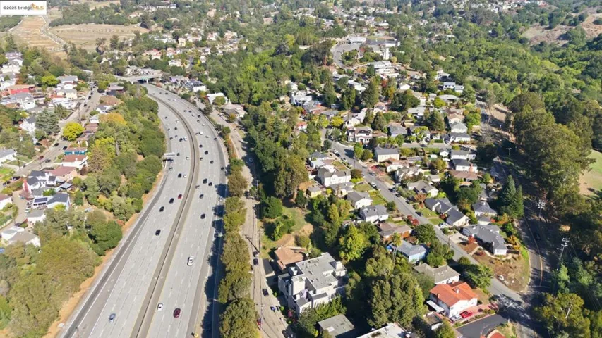 Aerial view of property and surrounding area with a major roadway and nearby suburban area