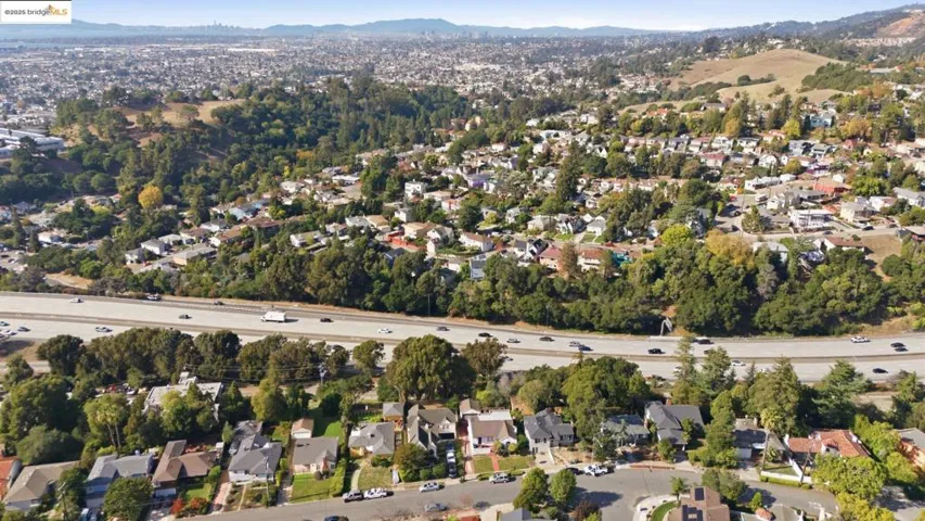 Aerial overview of property's location with nearby suburban area and a mountainous background