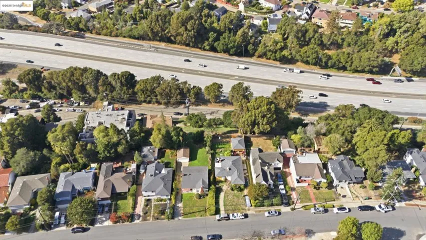 Aerial view of property's location featuring a tree filled landscape and nearby suburban area