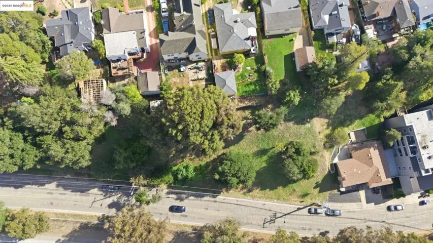 Aerial view of property and surrounding area featuring nearby suburban area