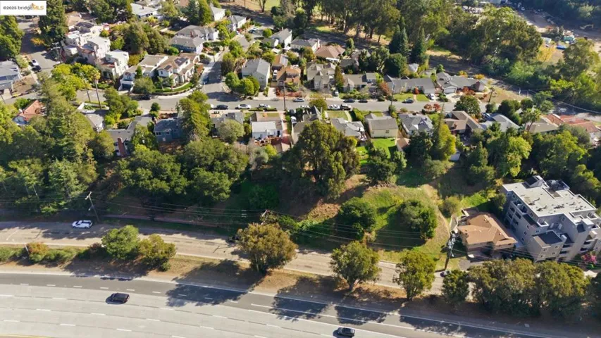 Aerial view of property and surrounding area featuring a tree filled landscape