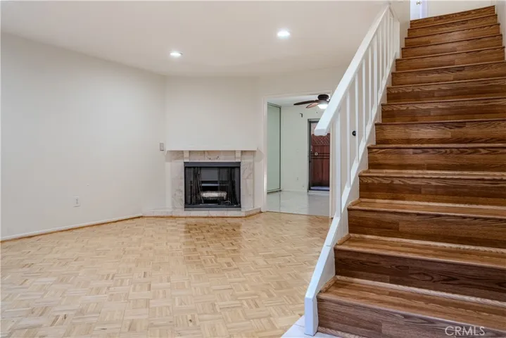 Living room with a decorative fireplace, leading straight into the kitchen,  perfect for hosting.