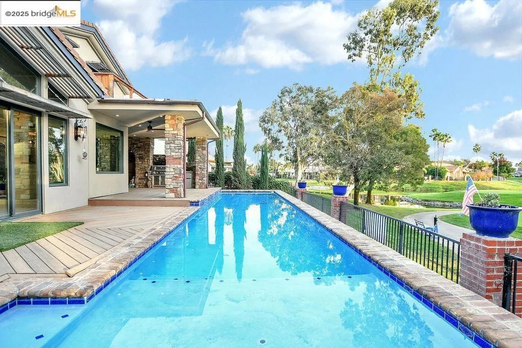 View of swimming pool with a patio, ceiling fan, and a lawn