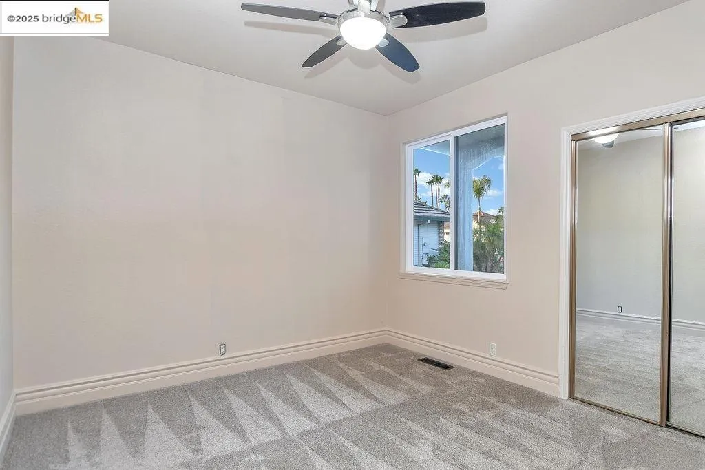Unfurnished bedroom featuring light carpet, a closet, and ceiling fan