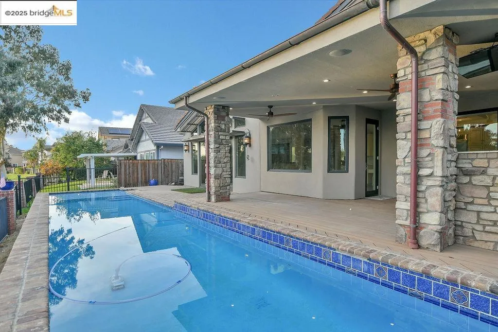 View of pool featuring a ceiling fan and a patio