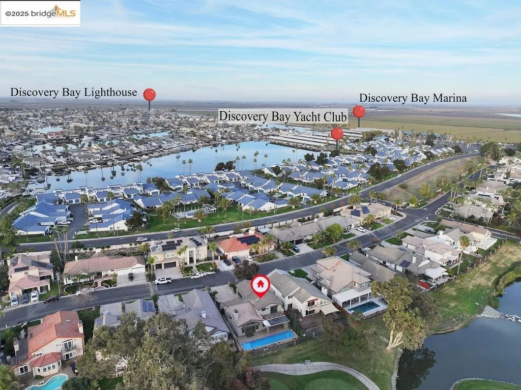Aerial overview of property's location featuring a nearby body of water and nearby suburban area