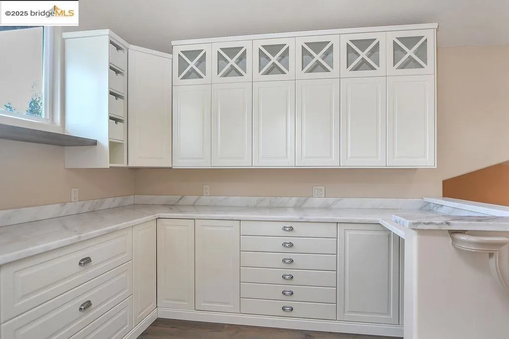 Kitchen with light countertops, white cabinets, open shelves, and dark wood-type flooring