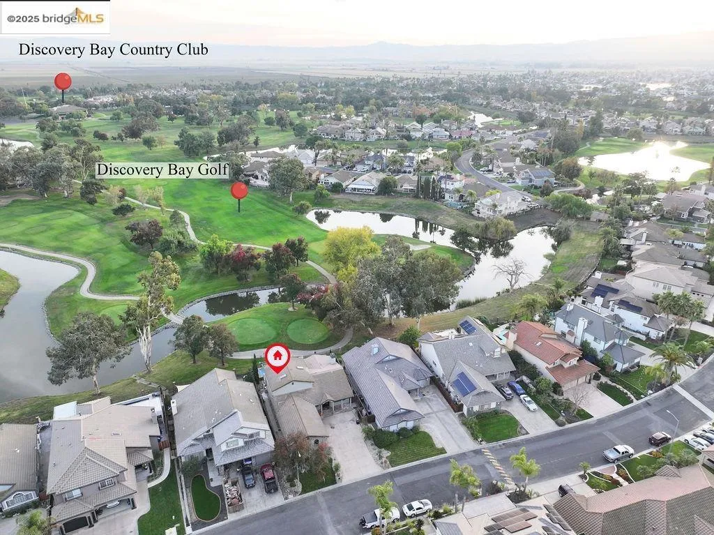 View of property location with nearby suburban area, a large body of water, and a local golf course