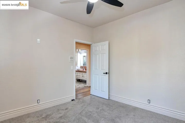 Carpeted spare room featuring baseboards and a ceiling fan