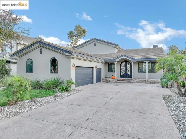Ranch-style home featuring stucco siding, a garage, and driveway