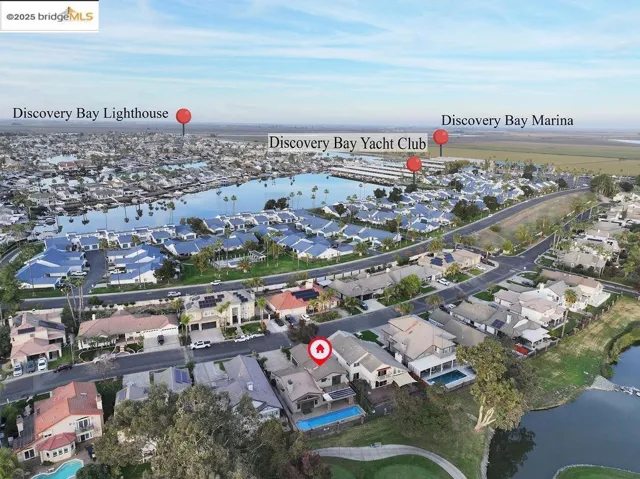 Aerial overview of property's location featuring a nearby body of water and nearby suburban area
