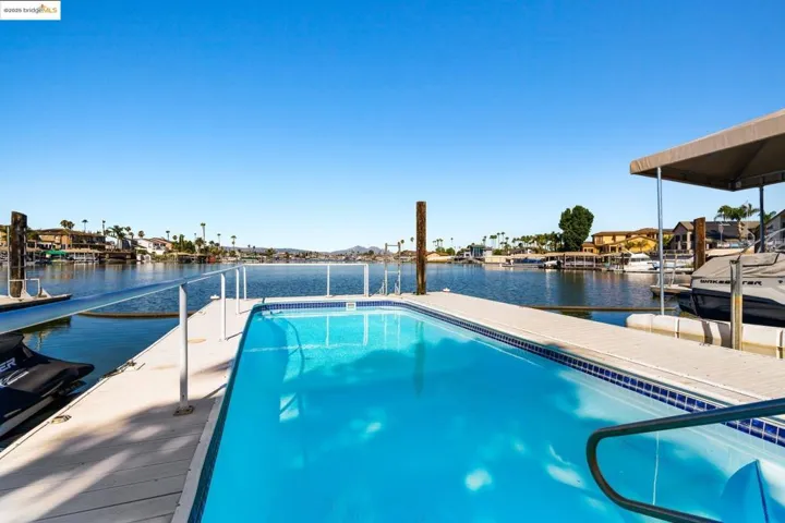 Outdoor pool featuring a dock and a water view