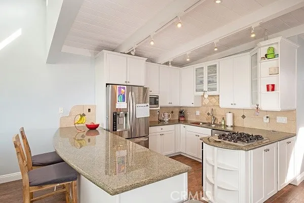 Kitchen features Granite counter tops, breakfast bar for easy seating, stainless steel appliances, custom wood cabinetry and tile back-splash