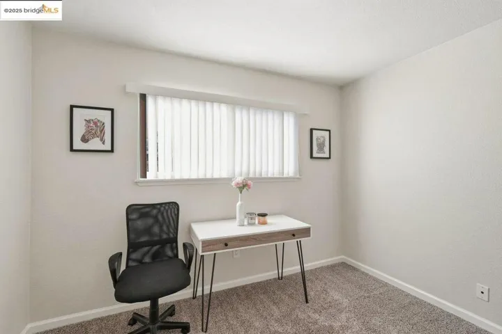 Carpeted office space with baseboards