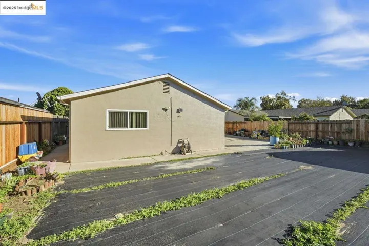View of property exterior with a fenced backyard and stucco siding