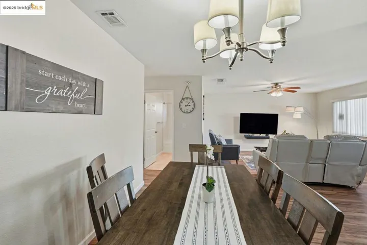 Dining room with a chandelier, wood finished floors, and ceiling fan