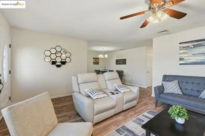Living room featuring a chandelier, wood finished floors, and a ceiling fan