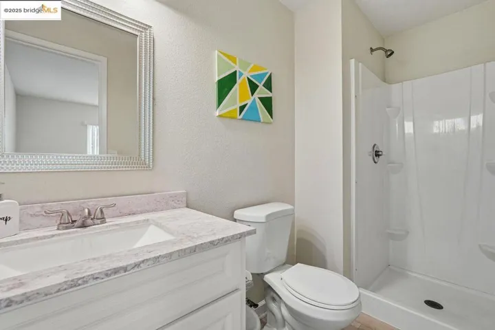 Bathroom featuring vanity, a stall shower, and a textured wall