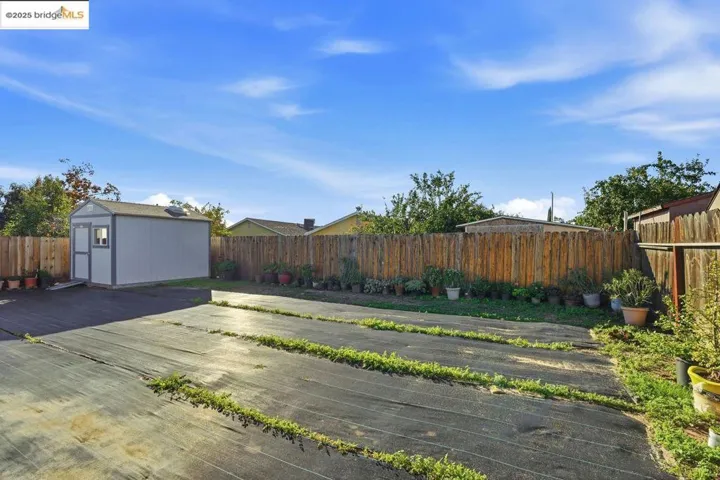 Fenced backyard with a storage shed and a deck