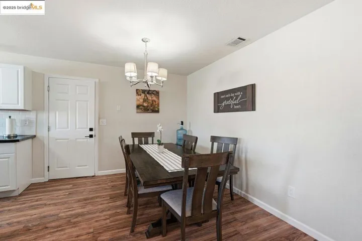 Dining area featuring dark wood-style flooring and a chandelier