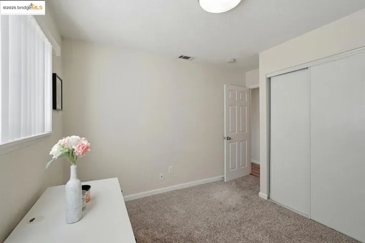 Unfurnished bedroom with light colored carpet and a closet
