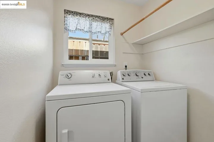 Laundry room with washing machine and clothes dryer and a textured wall
