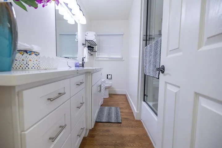 Beautifully updated bath with a wide quartz vanity, modern fixtures, glass-enclosed tub/shower, and elegant lighting. Clean lines and bright finishes create a spa-inspired feel in a thoughtfully designed layout. Essentials Included.