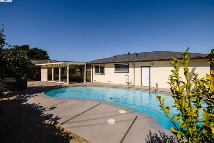 Enjoy a spacious 10-ft deep pool with a wide concrete deck, open yard, and plenty of sun—perfect for swimming, relaxing, or hosting. A great outdoor space ready for fun and comfort.